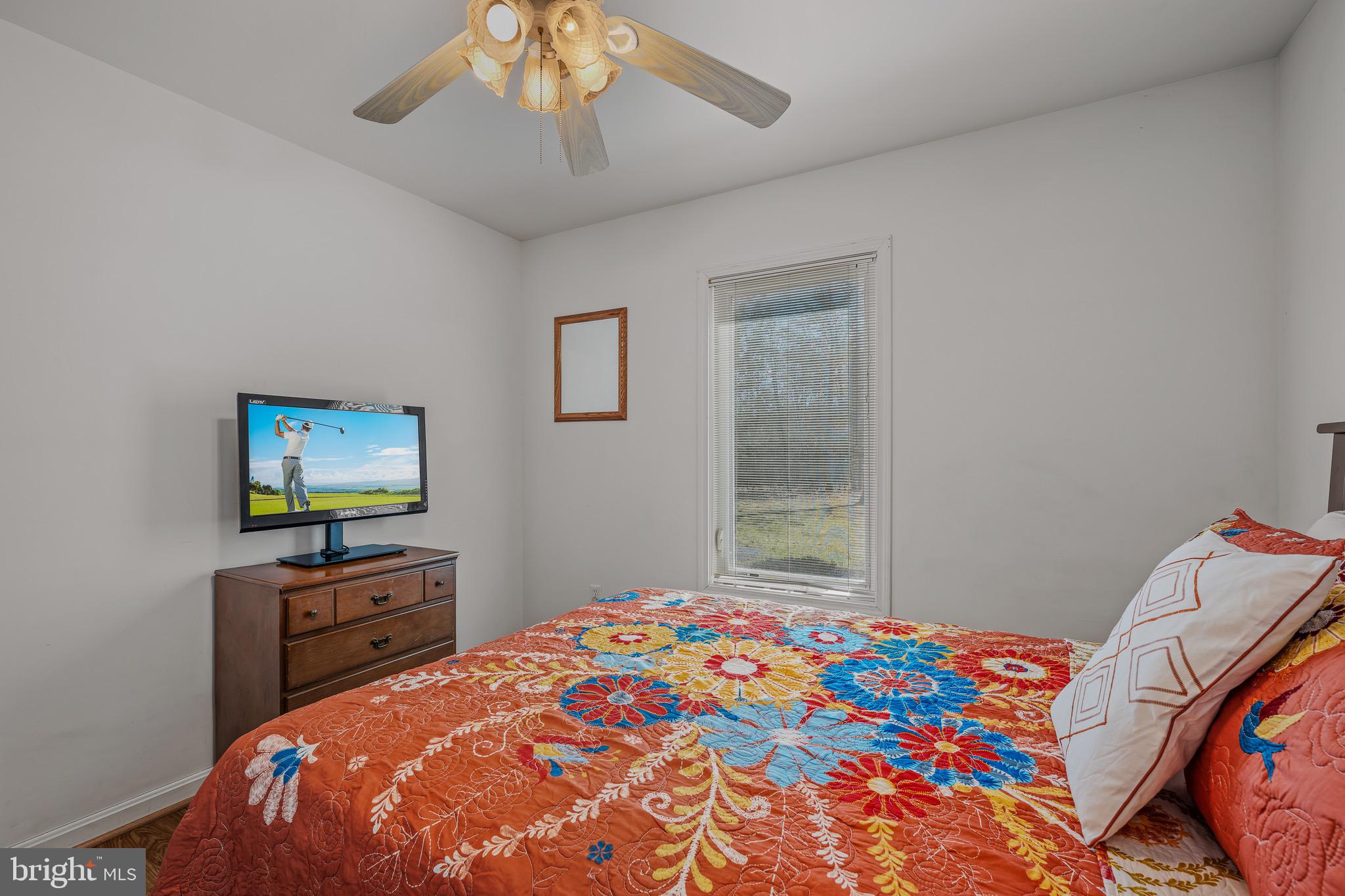 72 Medfords Lane Berkeley Springs, WV 25411 - Photo 18 of 52 a bedroom with a bed and a flat screen tv