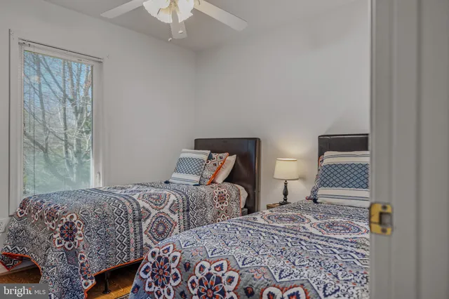 a bedroom with two beds and a lamp