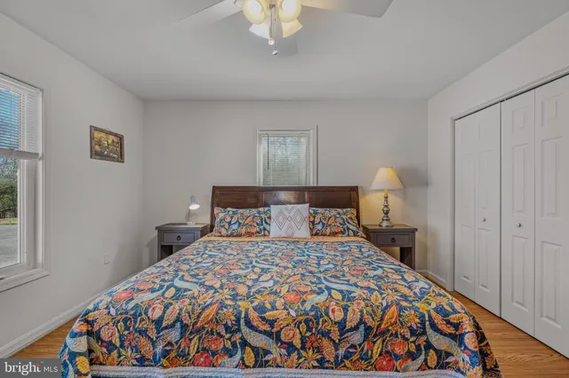 a bedroom with a bed and a lamp on dresser