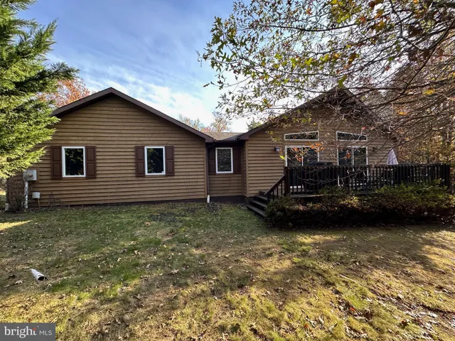 a view of a house with backyard and trees