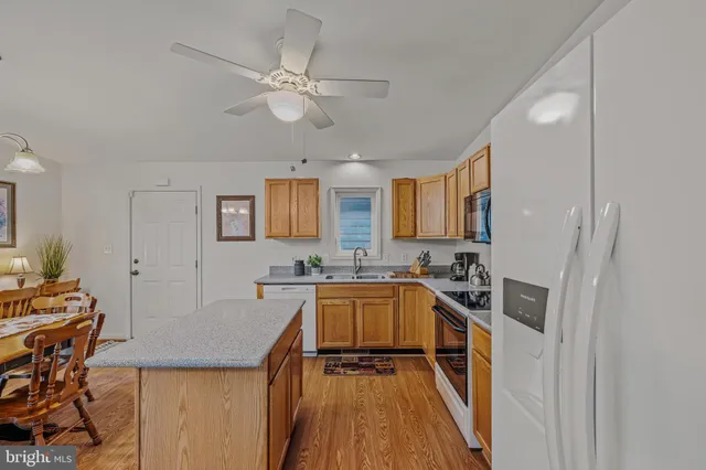 a kitchen with a sink a counter top space stainless steel appliances and cabinets