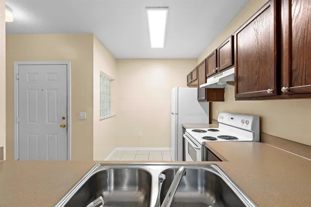 a kitchen with stainless steel appliances granite countertop a sink and a refrigerator
