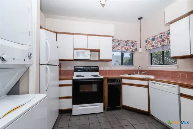 a kitchen with a stove sink and cabinets