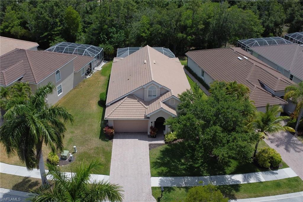 an aerial view of a house with garden space and trees all around