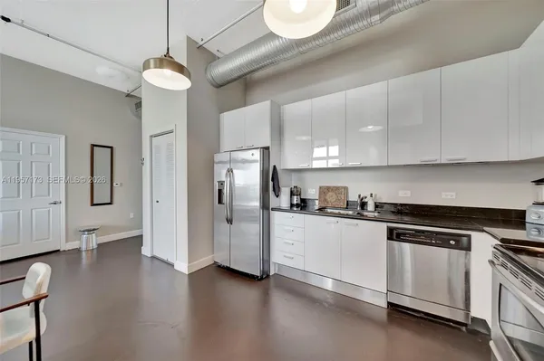a kitchen with stainless steel appliances a stove a sink and white cabinets