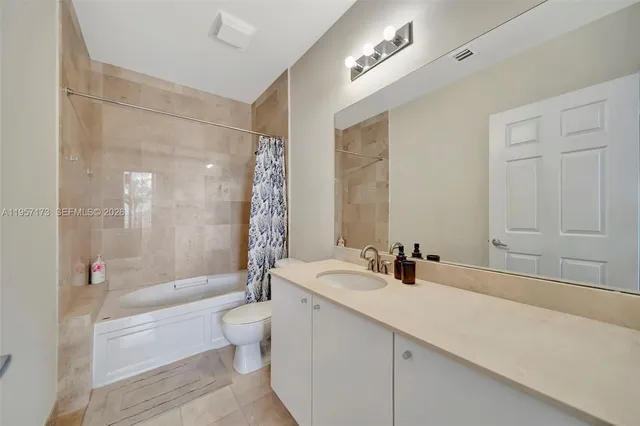 a bathroom with a double vanity sink toilet mirror and bathtub