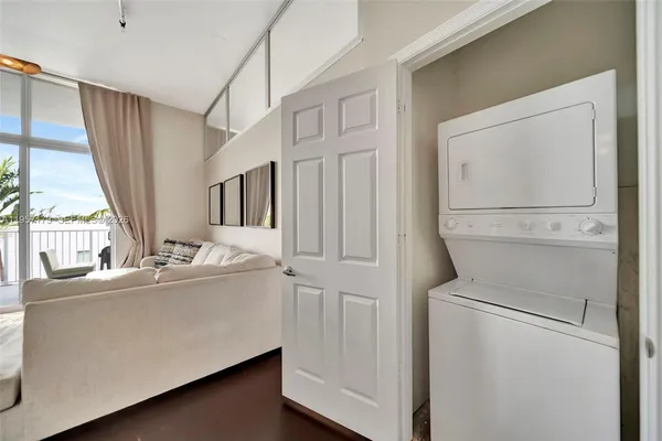 a view of washer and dryer with bathroom in the background