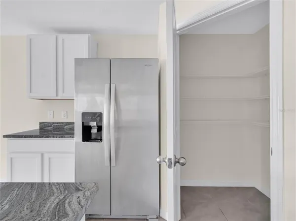 a kitchen with a refrigerator and a stove top oven