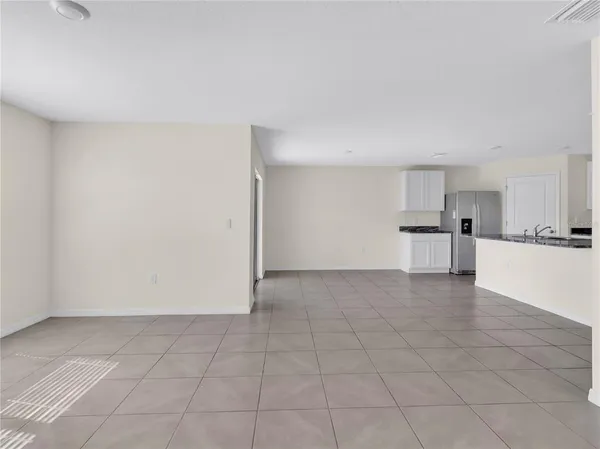 a view of kitchen with granite countertop cabinets and refrigerator