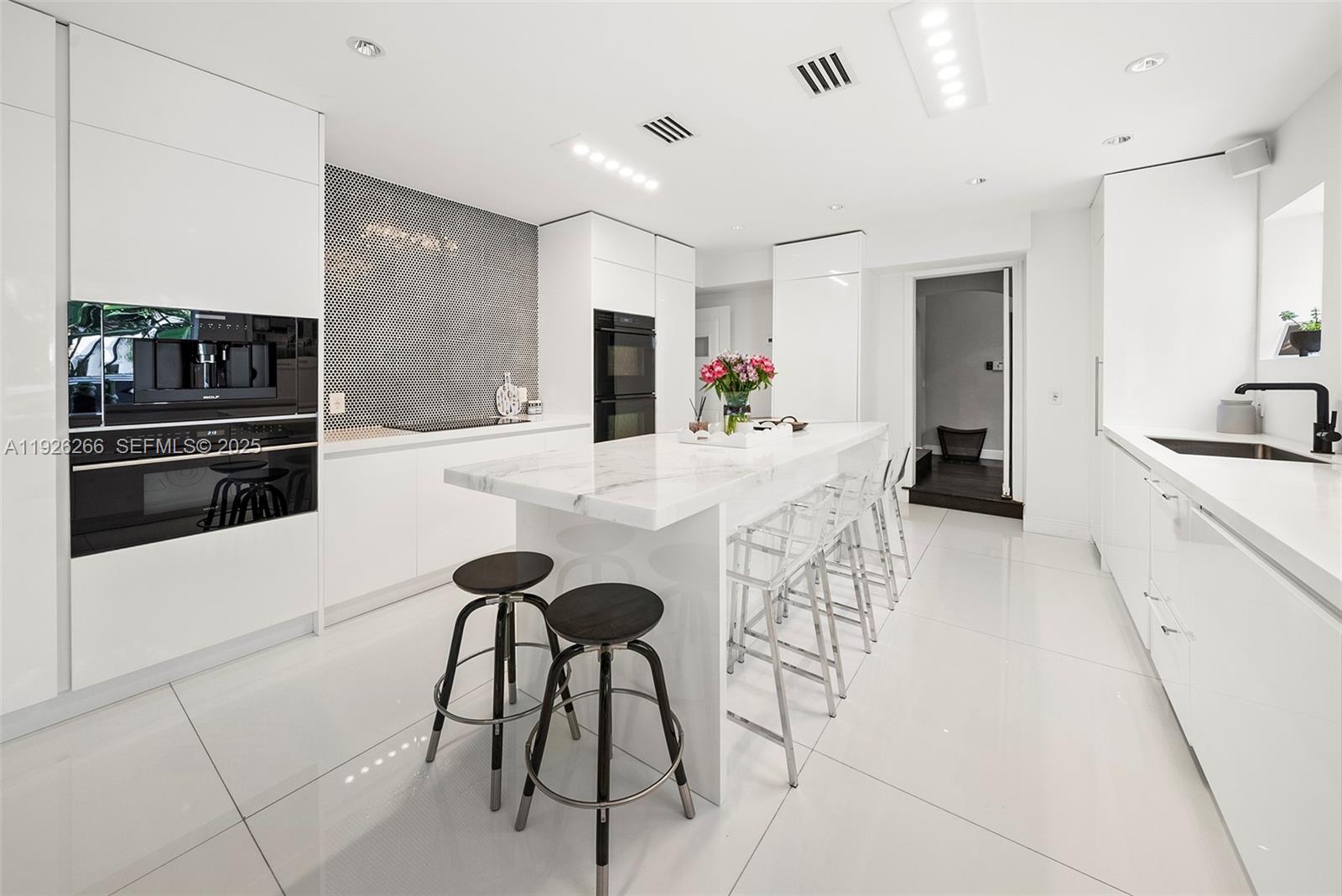 2729 North Bay Road Miami Beach, FL 33140 - Photo 5 of 41 a kitchen with stainless steel appliances kitchen island granite countertop a refrigerator and a stove top oven