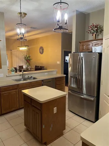 a kitchen with stainless steel appliances granite countertop a sink and a refrigerator