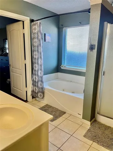 a bathroom with a granite countertop sink and a shower