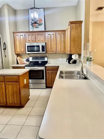 a kitchen with stainless steel appliances a stove a sink and a refrigerator