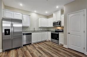519 West Bond Street Denison, TX 75020 - Photo 5 of 14 a kitchen with granite countertop a refrigerator and a stove top oven