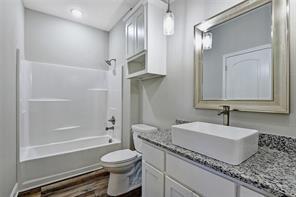 519 West Bond Street Denison, TX 75020 - Photo 9 of 14 a bathroom with a granite countertop sink toilet and shower