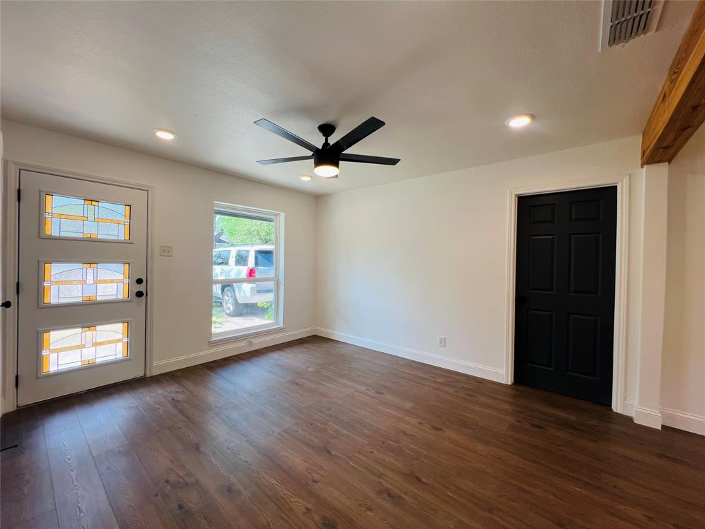 1621 Running River Road Garland, TX 75044 - Photo 5 of 20 a view of an empty room with wooden floor and a window