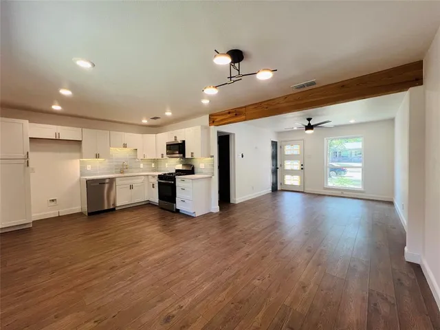 a view of a kitchen with a sink and a refrigerator