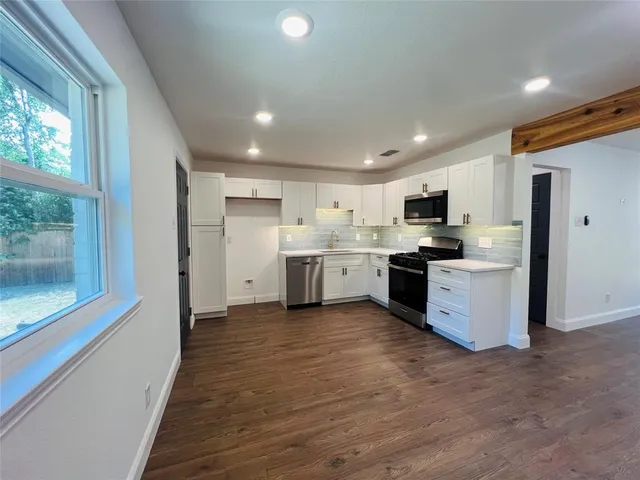 a kitchen with stainless steel appliances a refrigerator sink and cabinets