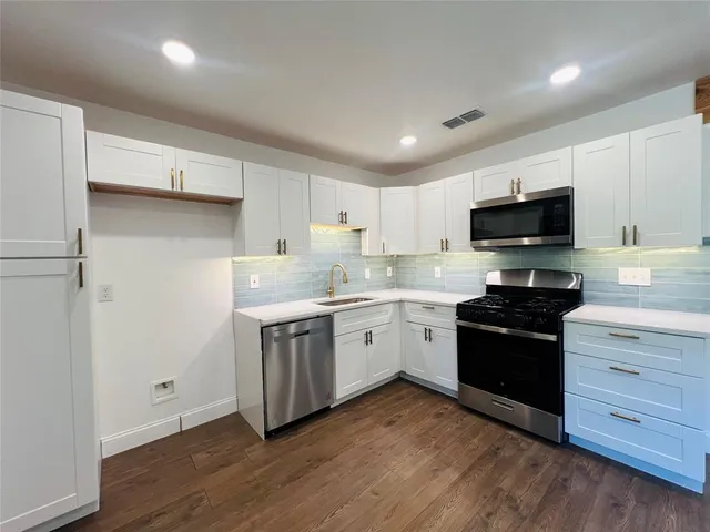 a kitchen with a stove a sink and a microwave