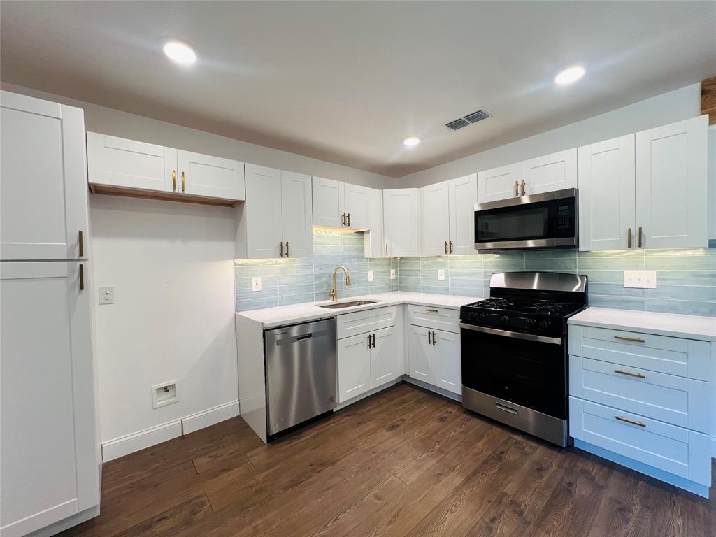 1621 Running River Road Garland, TX 75044 - Photo 9 of 20 a kitchen with a stove a sink and a microwave