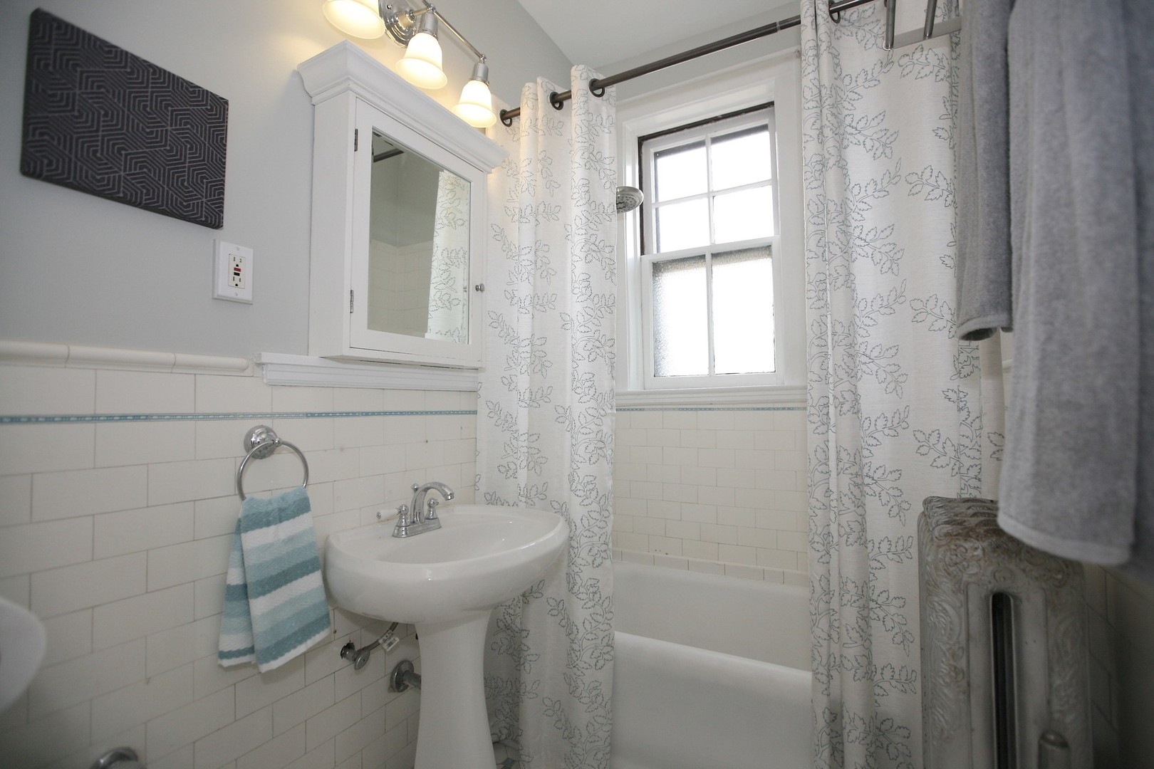 438 West Surf Street, Unit 3B Chicago, IL 60657 - Photo 16 of 36 a bathroom with a sink a mirror and a shower