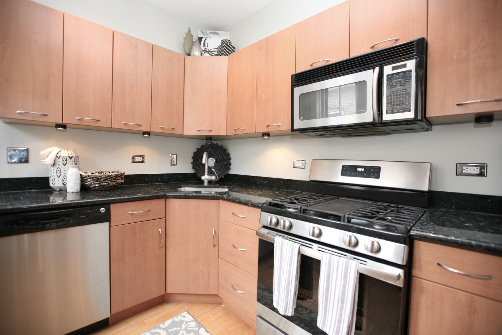 438 West Surf Street, Unit 3B Chicago, IL 60657 - Photo 4 of 36 a kitchen with stainless steel appliances granite countertop a sink stove and microwave