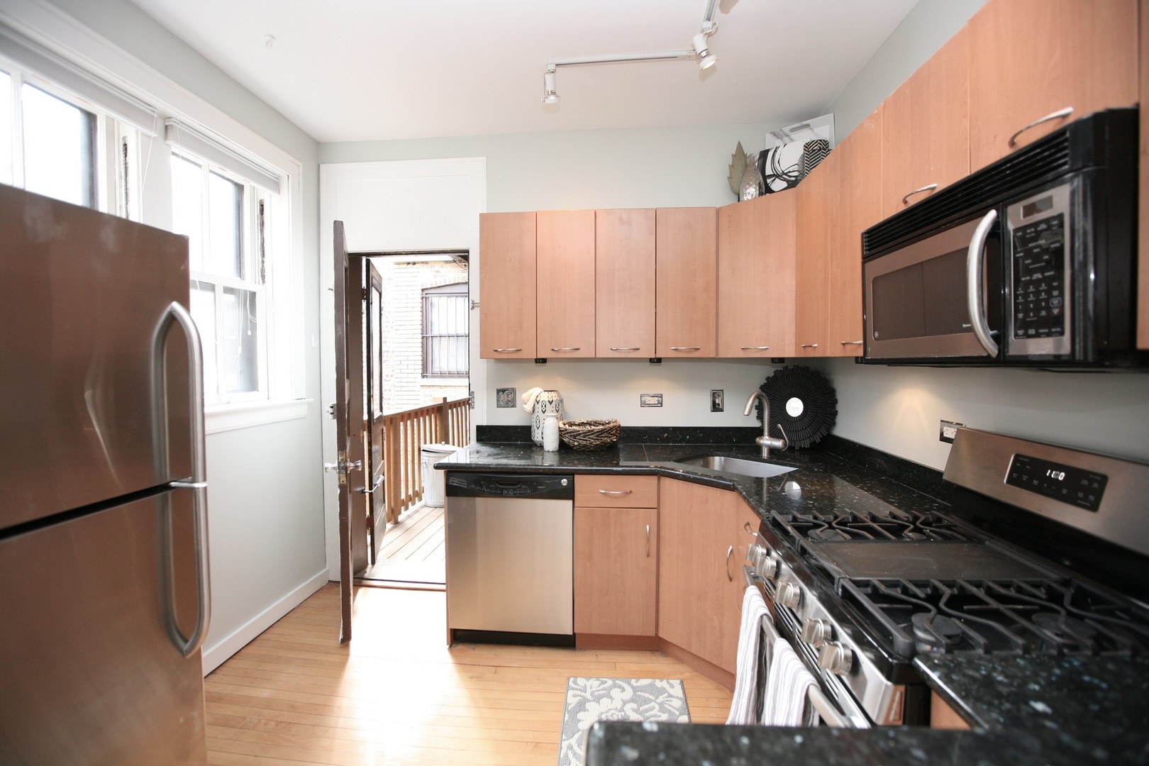 438 West Surf Street, Unit 3B Chicago, IL 60657 - Photo 5 of 36 a kitchen with stainless steel appliances granite countertop a refrigerator stove top oven and sink