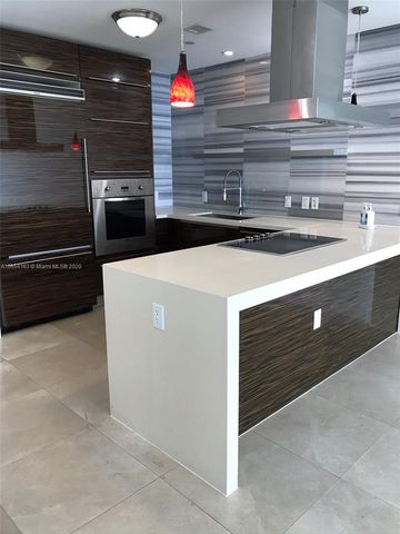a view of an empty room with wooden floor and windows