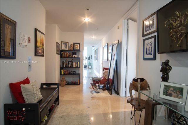 a bedroom with a bed a flat screen tv and a window