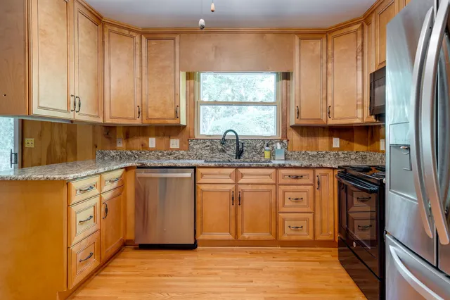 a kitchen with stainless steel appliances granite countertop a refrigerator sink and cabinets