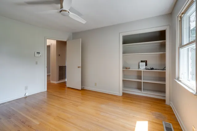 an empty room with closet and windows