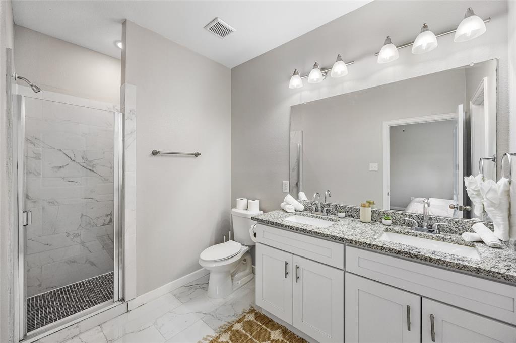 5006 Colonial Avenue Dallas, TX 75215 - Photo 23 of 25 a bathroom with a granite countertop sink a toilet and shower
