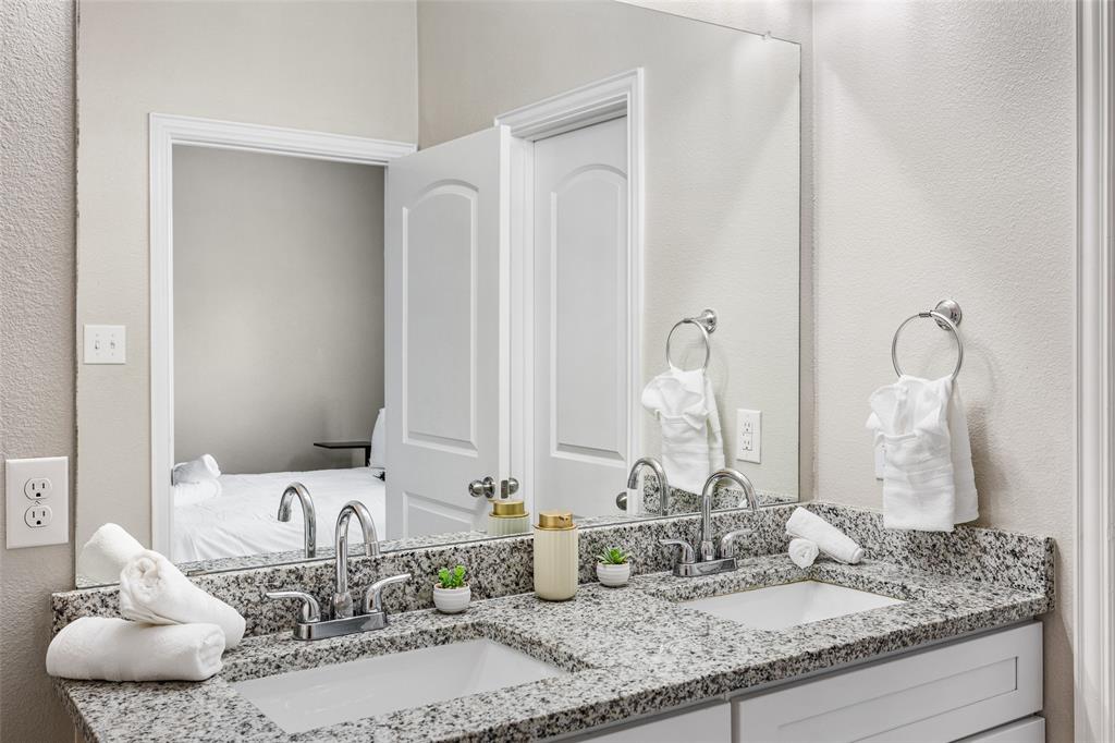 5006 Colonial Avenue Dallas, TX 75215 - Photo 24 of 25 a bathroom with a granite countertop sink and a mirror