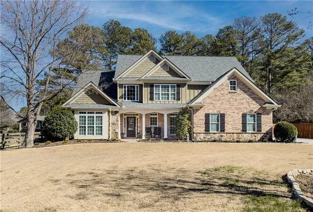 a front view of a house with a yard covered in snow