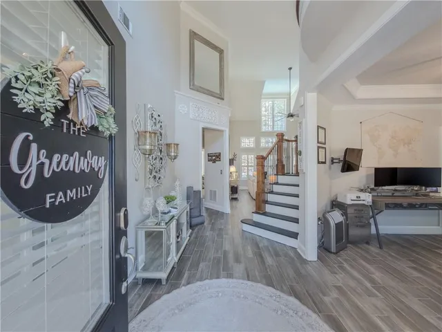 a view of a room with lots of white furniture and wooden floor