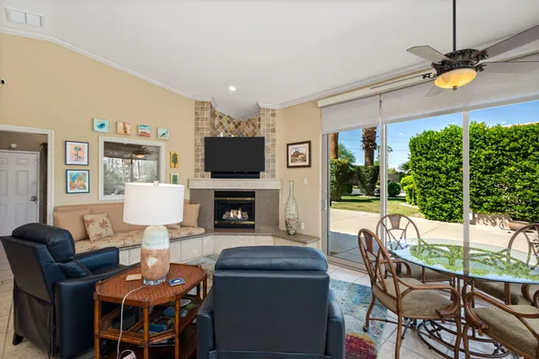 a living room with furniture a fireplace and a floor to ceiling window
