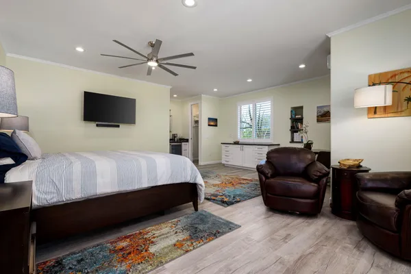 a spacious bedroom with a bed a couch and a flat screen tv