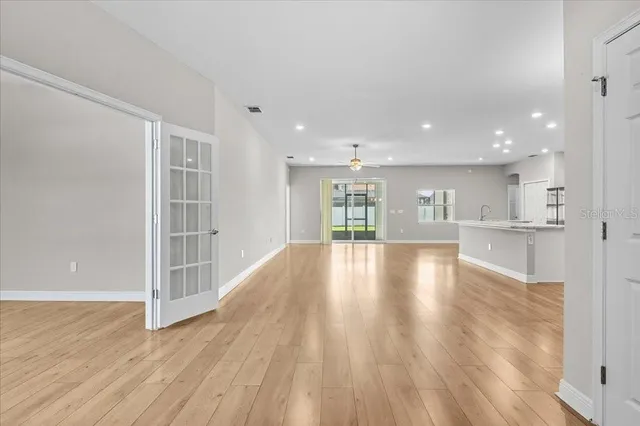 a view of empty room with wooden floor and windows