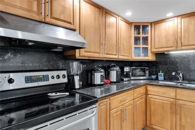a kitchen with stainless steel appliances granite countertop a sink and cabinets