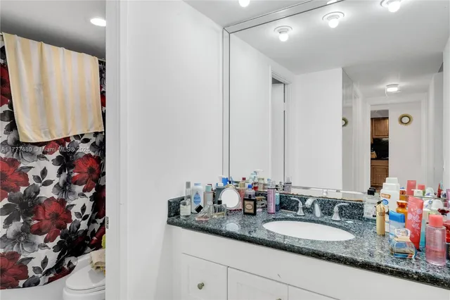 a bathroom with a granite countertop sink mirror and vanity
