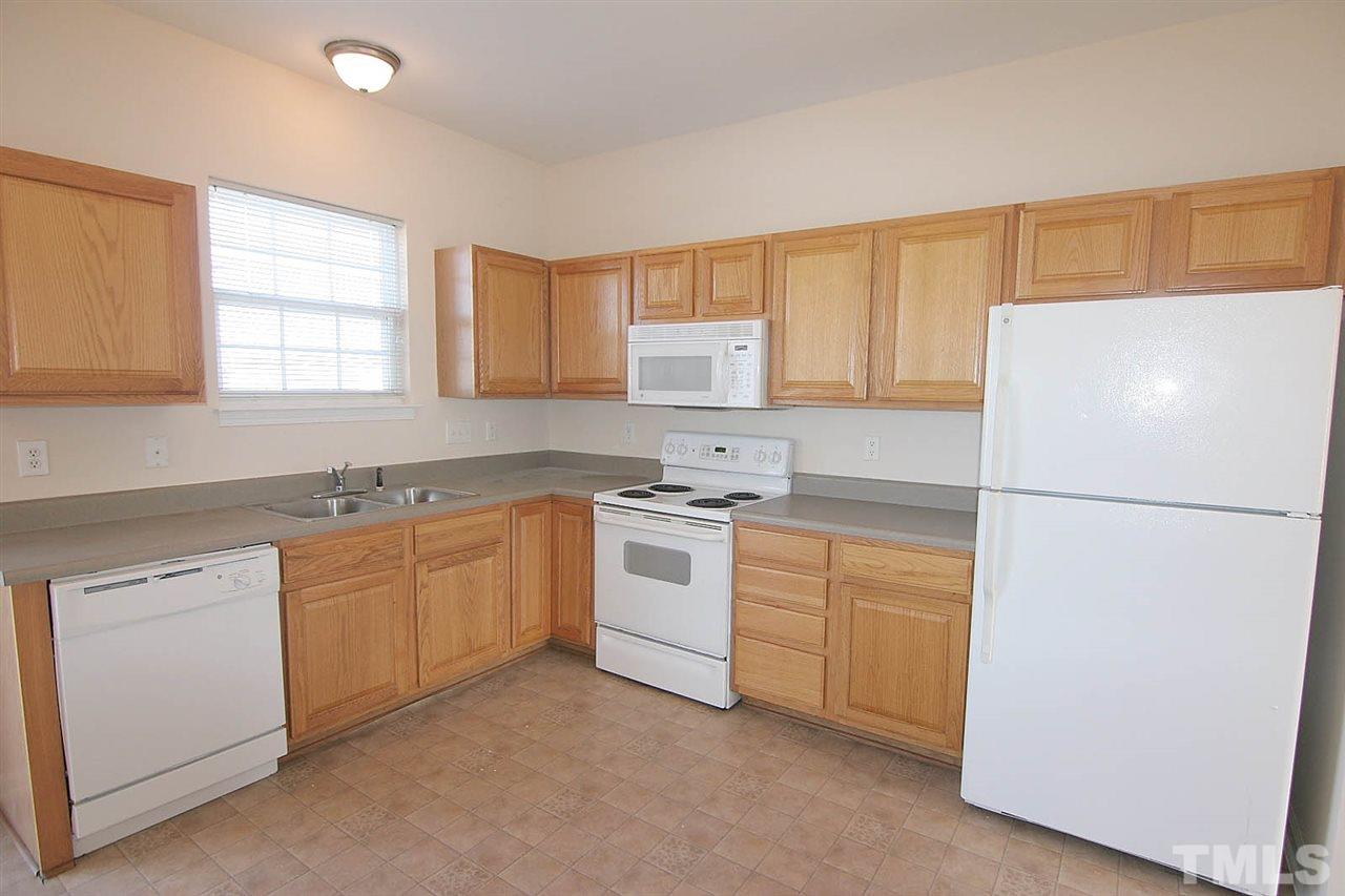 7009 Spanglers Spring Way Raleigh, NC 27610 - Photo 5 of 25 a kitchen with a white cabinets and white appliances