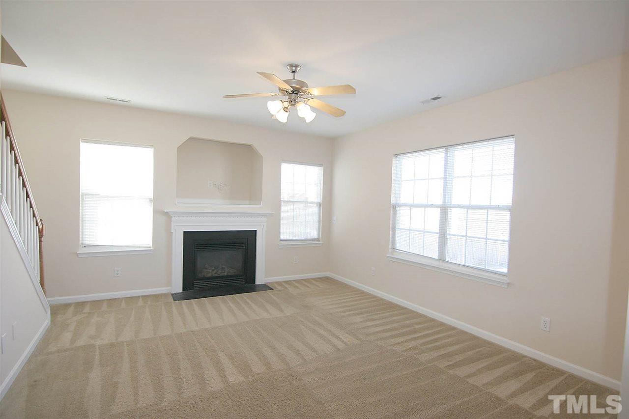 7009 Spanglers Spring Way Raleigh, NC 27610 - Photo 8 of 25 an empty room with windows and fireplace