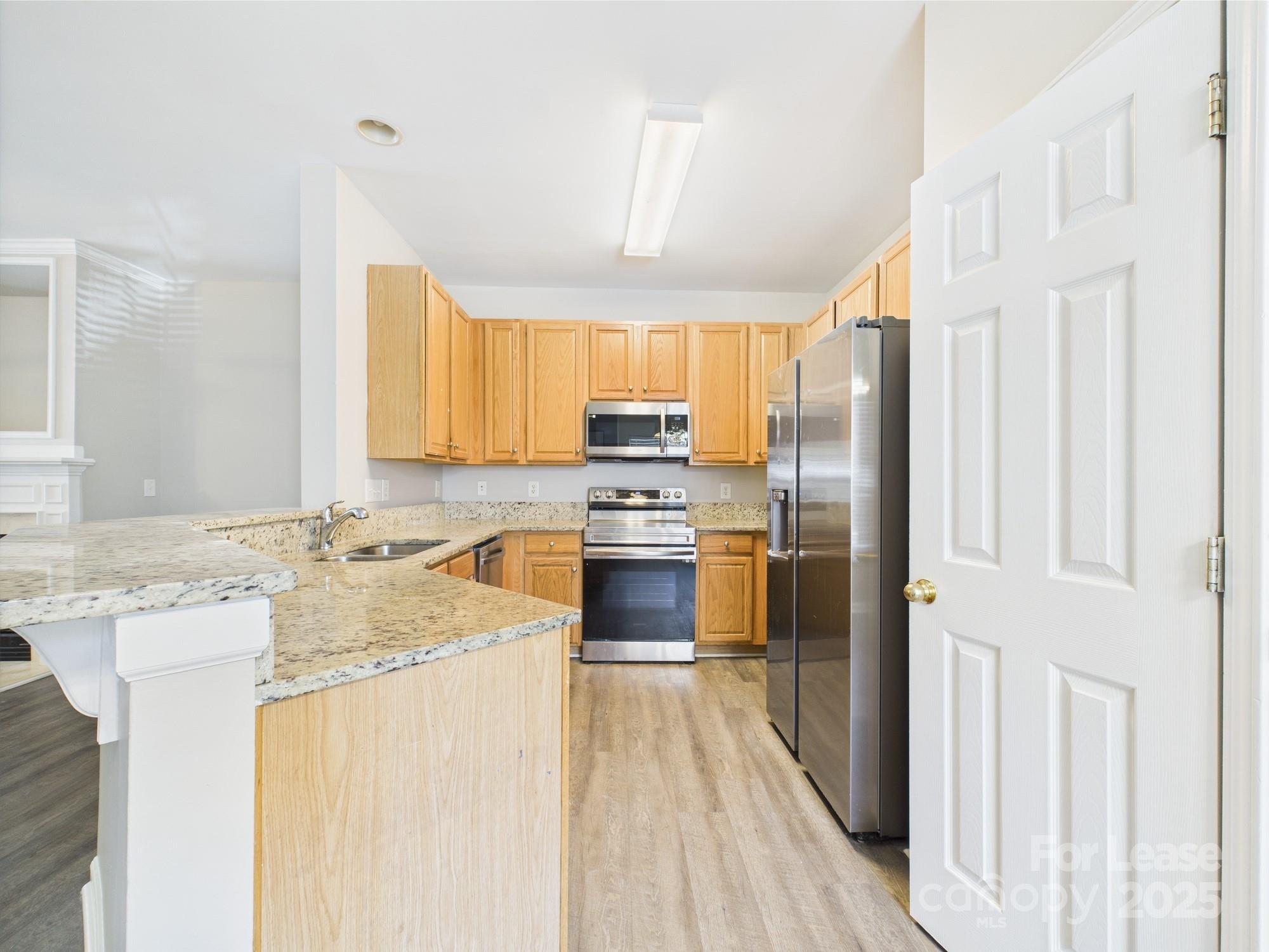 5706 Bent Creek Circle Charlotte, NC 28227 - Photo 5 of 13 a kitchen with granite countertop a stove a sink and a refrigerator