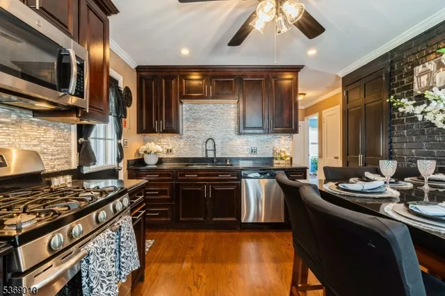 a kitchen with stainless steel appliances kitchen island granite countertop a stove and a sink