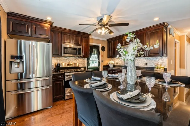 a kitchen with a refrigerator a stove a sink and dishwasher with wooden floor