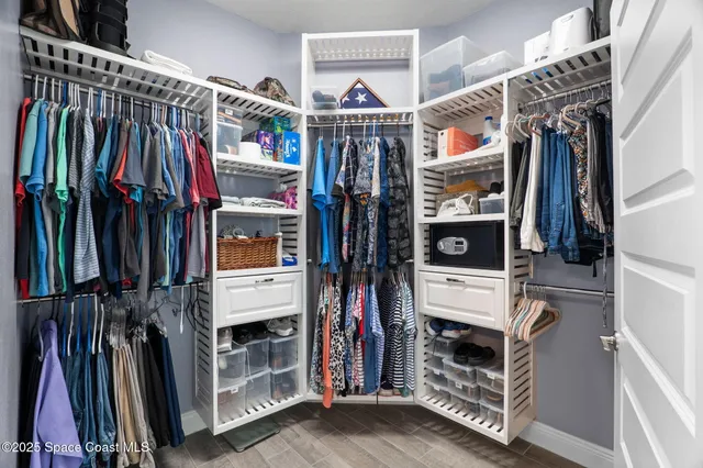 a view of walk in closet with clothes and shoes