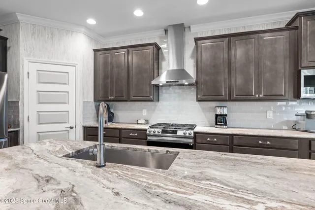 a kitchen with stainless steel appliances granite countertop a refrigerator and a stove top oven