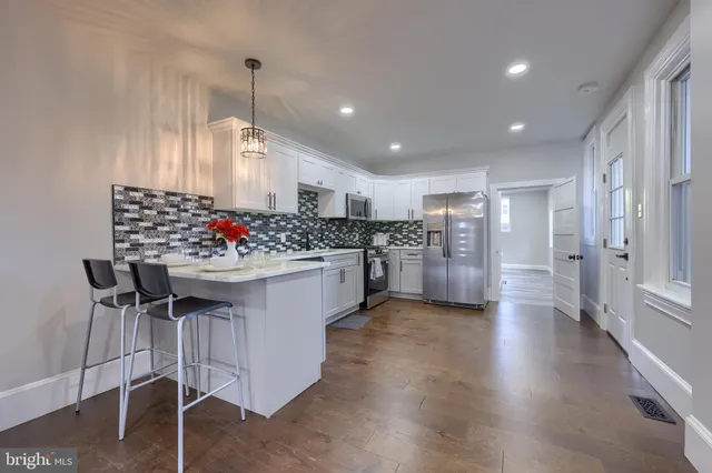 a kitchen with stainless steel appliances kitchen island granite countertop a stove and white cabinets