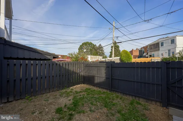 a backyard of a house with lots of green space and wooden fence
