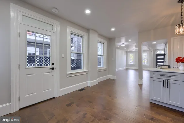 a view of a hallway with wooden floor and a living room